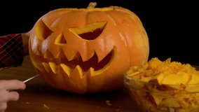 Scraping fresh pumpkin while making a lantern. Preparation of paraphernalia for the autumn holiday. A gloved hand takes out the seeds with a - Powered by Shutterstock - Get 15% off with code: PIKWIZARD15