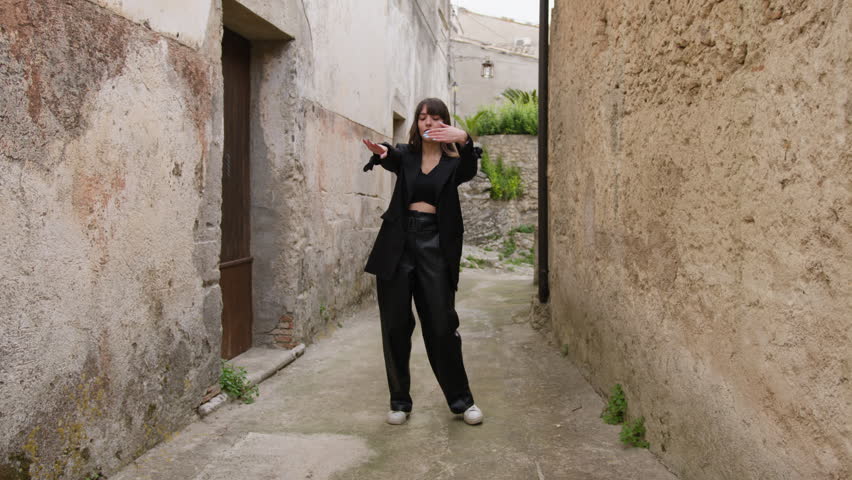Woman Dressed In Black Dances Through the Alleys Of The Village