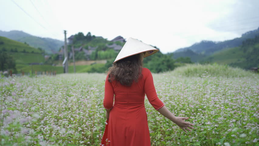 A farmer woman with fresh paddy rice terraces, green agricultural fields in countryside or rural area of Mu Cang Chai, mountain hills valley in Asia, Vietnam. Nature landscape. People lifestyle.