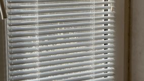 Old plastic window partly closed with the horizontal window Venetian blinds, inside view while panning
 - Powered by Shutterstock - Get 15% off with code: PIKWIZARD15