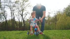 happy family. father teaches his baby toddler son to ride a bike. happy family kid dream concept. kid toddler learns to ride a bike with his father in park lifestyle, parent helps son playing - Powered by Shutterstock - Get 15% off with code: PIKWIZARD15
