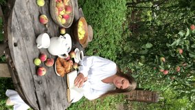 young woman model plus size in white dress sit at table with pet dog poodle, resting and drinking tea after harvesting autumn in back yard, fall and harvest, eco-friendly simple life, vertical video - Powered by Shutterstock - Get 15% off with code: PIKWIZARD15