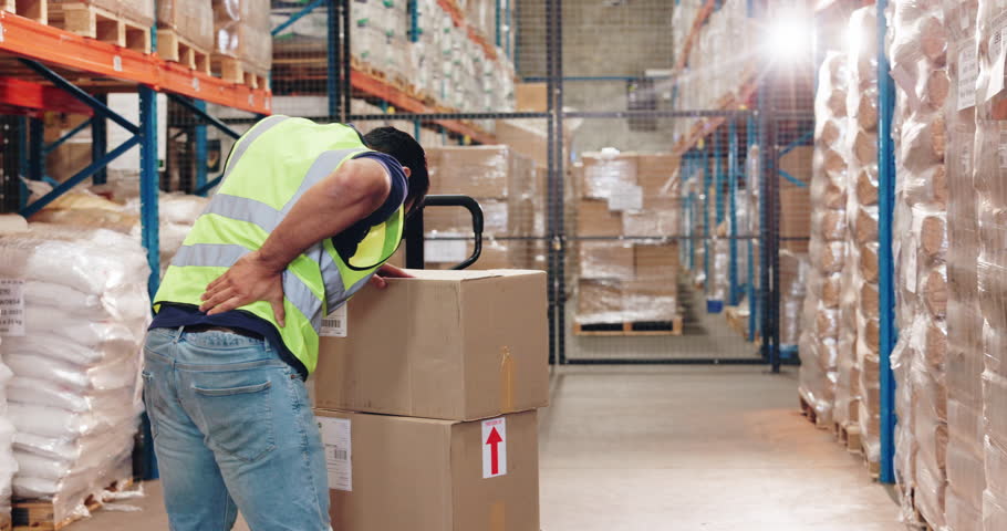 Man, logistics and warehouse with back pain of boxes, heavy lifting and manual handling for loading or packing. Person, strain and injury in factory for sorting for supply chain and distribution.