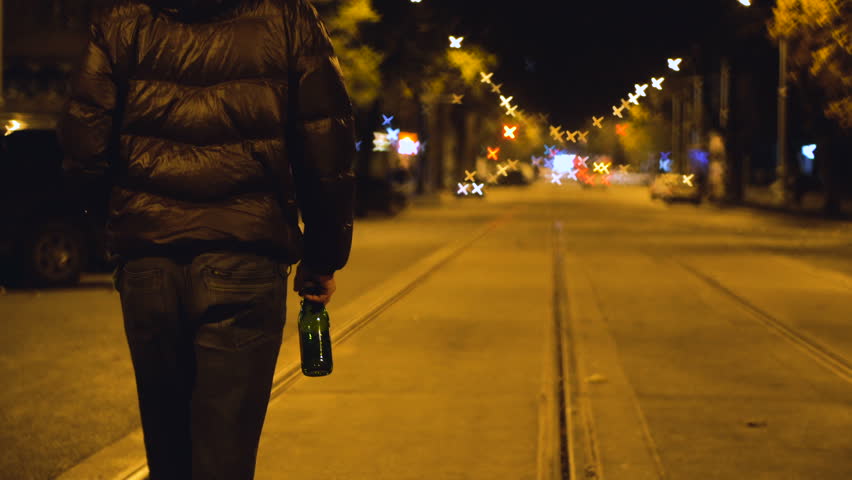 Drunk Man is Walking by the Night Carriageway Street and Drinking Beer form the Bottle Royalty-Free Stock Footage #35053987
