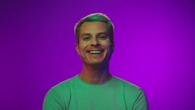 Happy Portrait of Adult Man Looking at Camera and Smiling in Neon UV Colors of Filter. 1 Handsome Face in Ultraviolet Light and Backlight Illumination. Cool 30s Person Having Fun Inside Amazing Studio - Powered by Shutterstock - Get 15% off with code: PIKWIZARD15