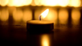 A wax tealight candle on fire. - Powered by Shutterstock - Get 15% off with code: PIKWIZARD15