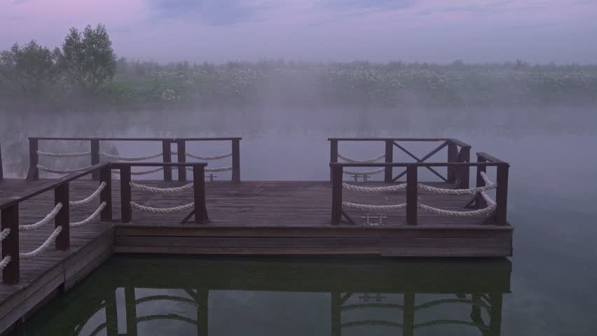 Landscape photo of wooden bridge standing on foggy lake at the morning time	