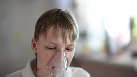 closeup of a boy receiving treatment for asthma from a nebulizer 