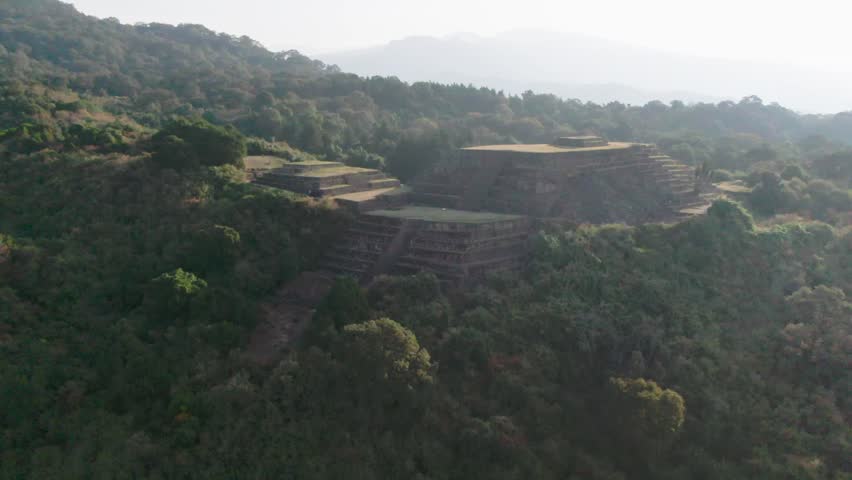 Purepecha Piramid in Mexico, the drone fly over the mountain at sunrice to reveal the piramid