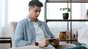 Emotional young man watching shocking videos on smartphone at home, getting amazed - Powered by Shutterstock - Get 15% off with code: PIKWIZARD15