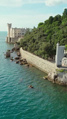 Beautiful aerial view of the Miramare Castle at the Adriatic sea coast in Italy. Drone revealing footage of the Miramare castle near Trieste, Italy. Italian summer holidays travel destination
