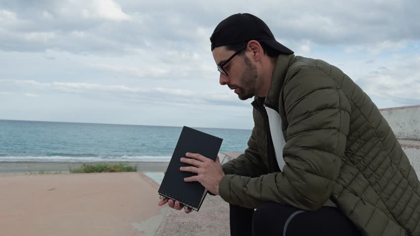 Man Reading A Book Near The Sea 