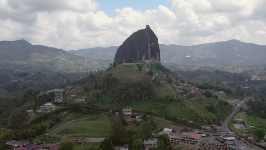 Orbit shot of El Peñón de Guatapé, a large, unique rock standing alone with stairs to the top and offering panoramic views, Guatapé, Colombia