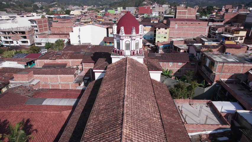 Drone backward view of the Iglesia Guatape church cathedral in the city center of a small colonial village close to Medellin. Antioquia tourist attraction, South America, Colombia.