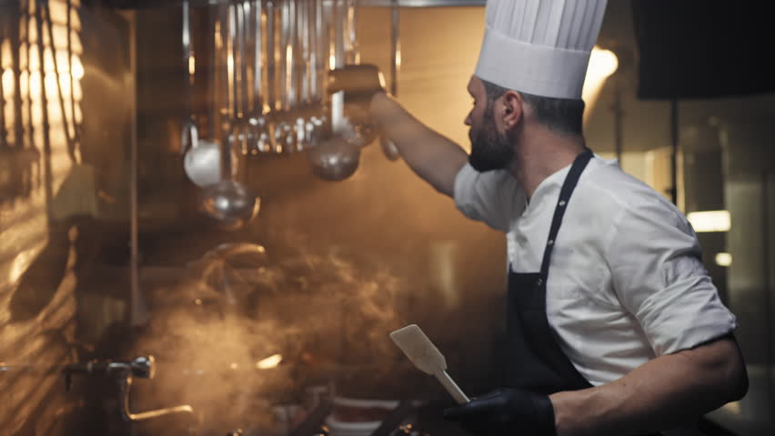 Steam vapor and lights surrounding the work of a chef 