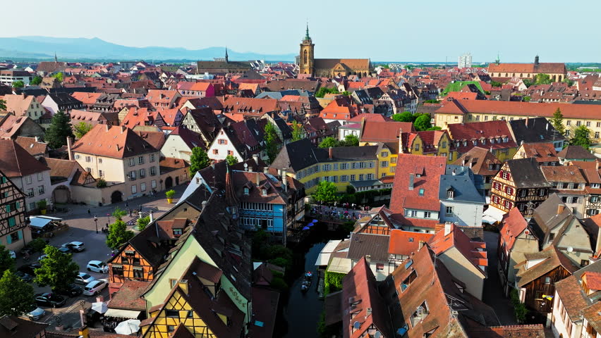 Aerial view of Le Petite Venise Alsatian half-timbered houses along riverbanks in Colmar. Tourists visit the Historical landmark Little Venise by the bridge with colourful houses in Colmar, France.
