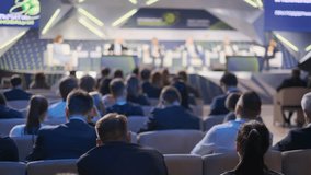 Audience members in a dimly lit hall watch speakers at a corporate conference event. Focus on engaged participants and professional setting. - Powered by Shutterstock - Get 15% off with code: PIKWIZARD15