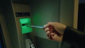 Close-up of a person's hand inserting a bank card into an ATM machine, ready for a transaction. The image represents banking, finance, and modern technology in everyday life. Hand Using ATM Machine - Powered by Shutterstock - Get 15% off with code: PIKWIZARD15