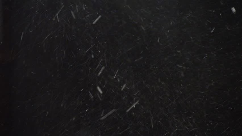 A real snow storm and a snow storm with a strong wind driving snowflakes in different directions isolated on a black background. Blowing Snow isolated on black, seamless loop with Alpha Matte.