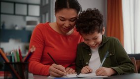 Laughing funny African American family woman mother female tutor teacher girl help little multiracial kid child adopted custody son boy with homework studying writing together laugh at home education - Powered by Shutterstock - Get 15% off with code: PIKWIZARD15