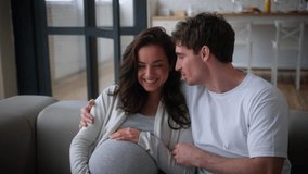 Pregnant happy cuddling family talking smiling laughing holding belly discuss fun at own rent home insurance medicine health couple man woman pregnancy girl guy husband wife female male at couch talk - Powered by Shutterstock - Get 15% off with code: PIKWIZARD15