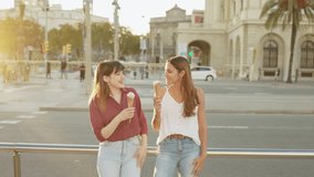 Two tourist friends relax eating a delicious ice cream while visiting the city of Barcelona on their summer holidays - Powered by Shutterstock - Get 15% off with code: PIKWIZARD15