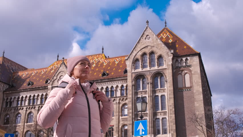 Woman interest for catholic place. A woman with interest look around the historical place with catholic church in Budapest.