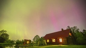 Northern lights above log cabin house in rural countryside timelapse on misty night - Powered by Shutterstock - Get 15% off with code: PIKWIZARD15