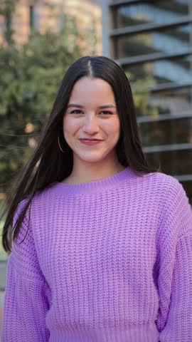 Vertical individual portrait of a joyful and adorable teenage hispanic woman with friendly expression. Happy latin young female student looking at camera enjoying smiling with a perfect white teeth