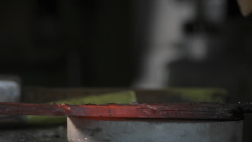 Blacksmith working with a steel brush on smelted hot metal