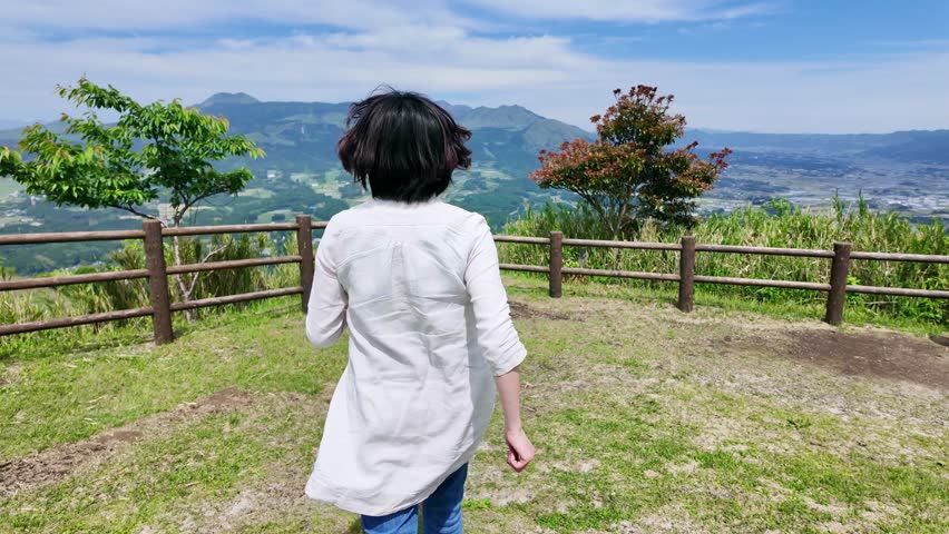 A woman looking at the natural scenery from an observation deck