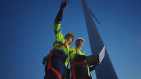 Diverse ethnicity male technicians working in the wind turbines field. Innovation engineer men wearing safety gear, work to develop environmental renewable clean energy outdoors at windmill power farm - Powered by Shutterstock - Get 15% off with code: PIKWIZARD15