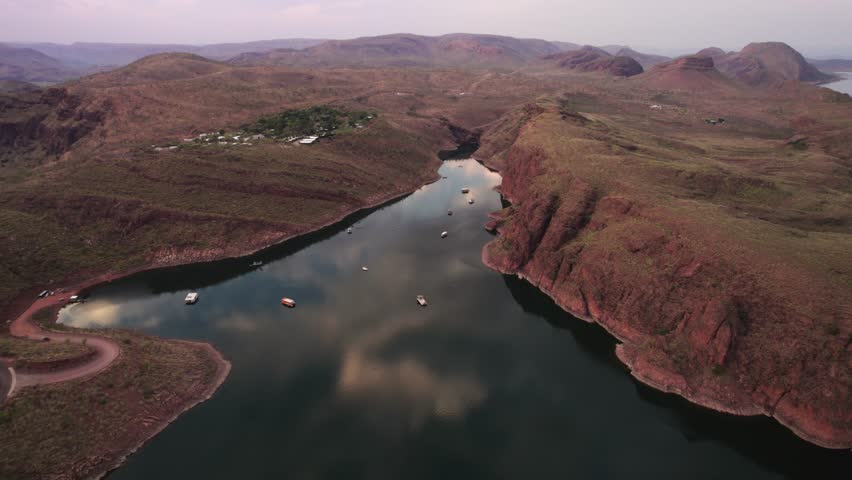 Aerial view of serene sunset over Lake Argyle with majestic mountains and tranquil valley, Queensland, Australia.