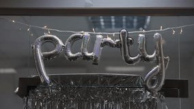 Inflatable letters Party. Silver inflatable Party letters in interior. Silver party balloons in apartment. Hanging inflatable celebration balloons. vertical video - Powered by Shutterstock - Get 15% off with code: PIKWIZARD15
