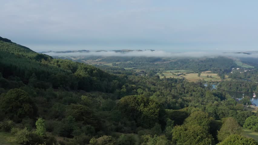 Aerial view of Lake Windermere surrounded by forest and mountains, Lake District, England.
