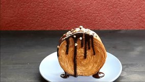 Footage of a Delectable Supreme Croissant or New York Roll Topped with Chocolate Sauce and Chopped Nuts - Powered by Shutterstock - Get 15% off with code: PIKWIZARD15