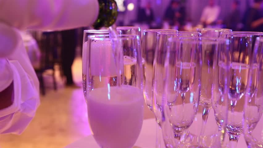 The waiter pours champagne in glasses, Glasses with champagne on the table in the restaurant, glasses of champagne on festive table, Clean glasses on a table prepared by the bartender for champagne Royalty-Free Stock Footage #35070625