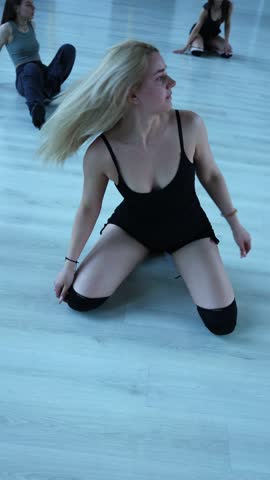 A group of girls is dancing the Hills routine in a dance class. Vertical video. Feminine dance. Flipping their hair