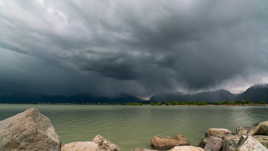 Rainstorm moving over Timpanogos Mountain viewed from Utah Lake in timelapse.