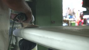 Surf board maker uses orbital sander electric tool to shape and smooth the board in workshop - slow motion - Powered by Shutterstock - Get 15% off with code: PIKWIZARD15