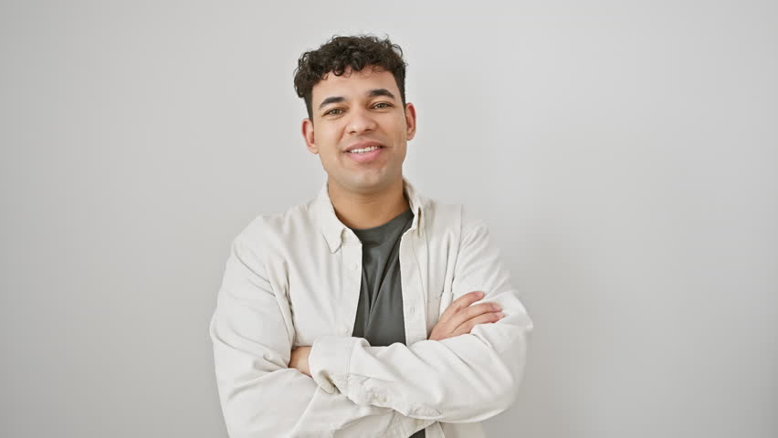 Young arab man wearing casual clothes happy face smiling with crossed arms looking at the camera. positive person. over isolated white background