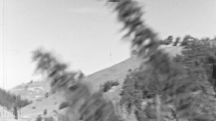 Mountainous Landscape Dotted with Scattered Vegetation Under a Bright Sky. Imparting a Sense of Movement or Haste within the Natural Environment. Black and White Vintage Footage. Wyoming USA.