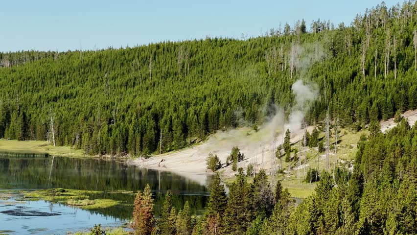 Yellowstone Park with rushing geysers, multicolored hot springs, crystal clear lakes and impressive canyons. Bears and bison. Wyoming, Idaho and Montana. Yellostone natural spectacle. Sunset.