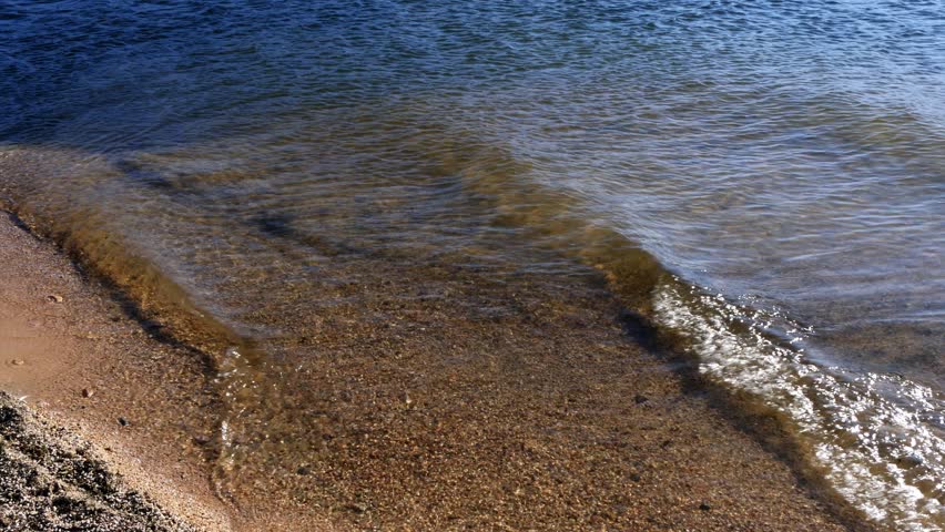 Small beautiful waves on the sandy shore of a transparent lake
   Mongolia.