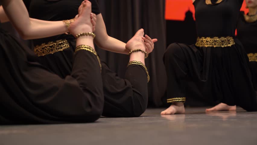 The legs of four young Indian dancers performing folk dances on stage. Women in traditional clothes dancing. High quality 4k footage