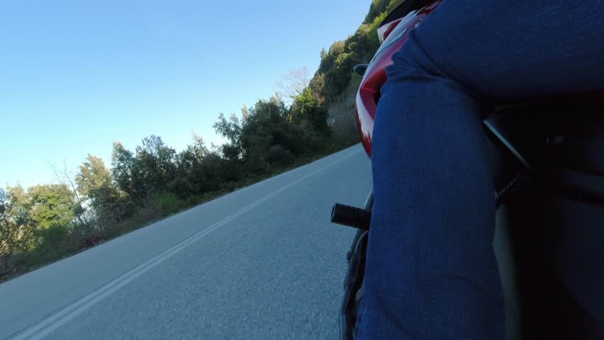 Riding Motorcycle in Curvy Mountain Road, Leaning Through Turns, View from Left side Behind Riders Leg
