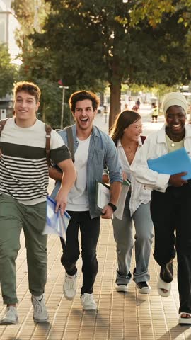 Group of students running in the street going to college school celebrating graduation