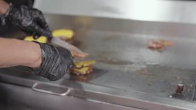 Chef making cheeseburgers with cheese on top in the restaurant's kitchen, smash burger