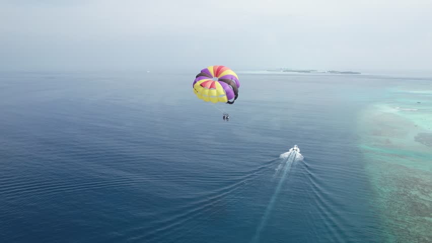Happy Honeymooner Couple Parasailing in the Maldives, Drone Closeup