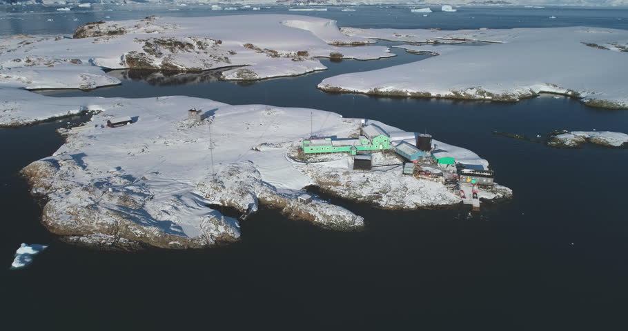South Pole science polar station in Antarctica. Research Vernadsky base buildings on ocean coastline aerial drone view. Global warming, climate change, wild nature exploration. Antarctic expedition